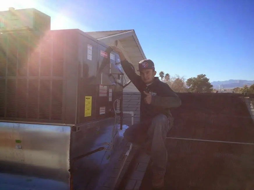 HVAC technician performing AC Tune-Up on a rooftop unit in Oakhurst